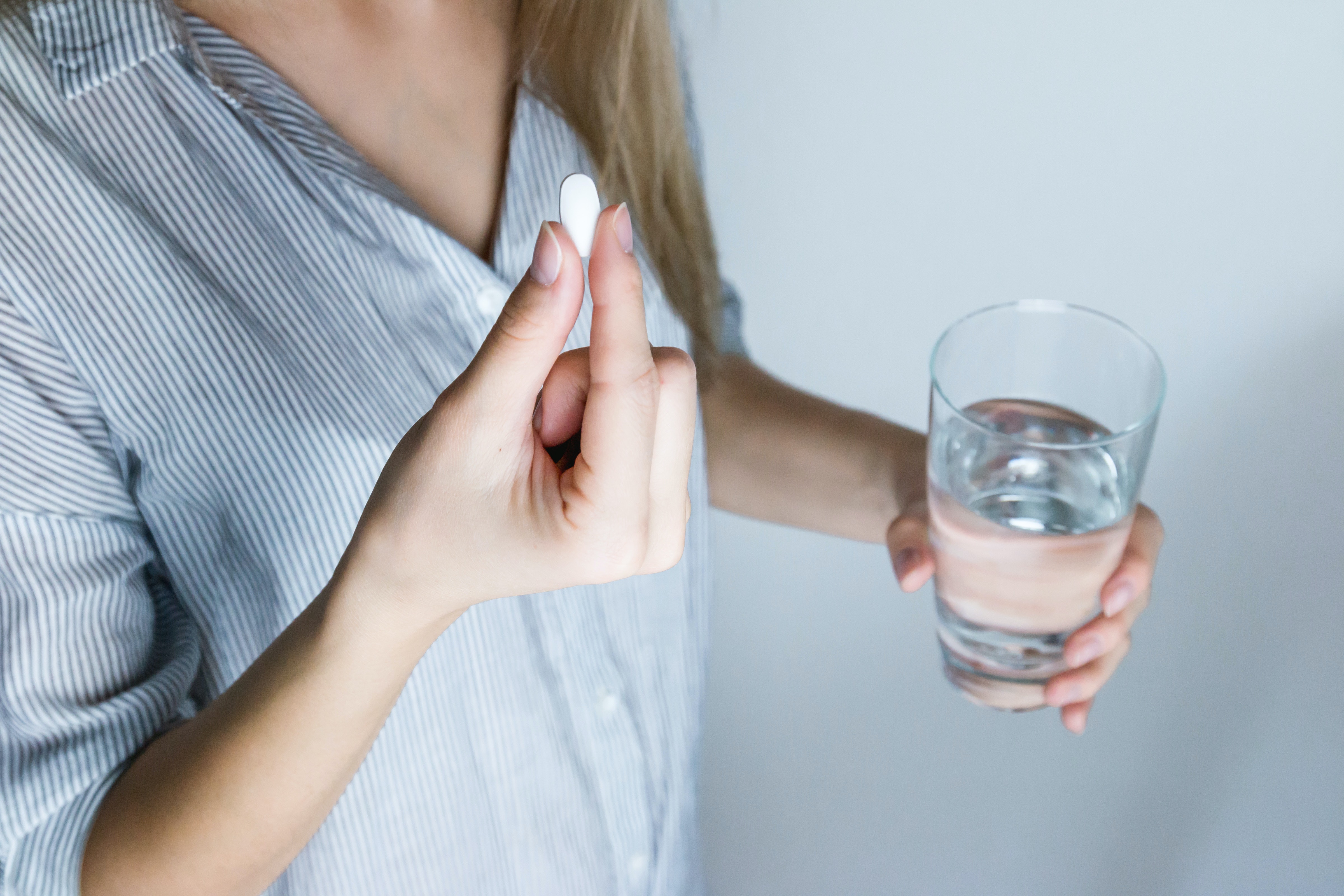 Kvinne holder en tablett og et glass vann