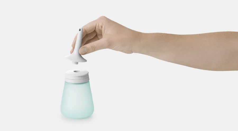 Bilde av Peristeen Light 250 ml. En hånd holder Peristeen Lights forhåndssmurte kateter