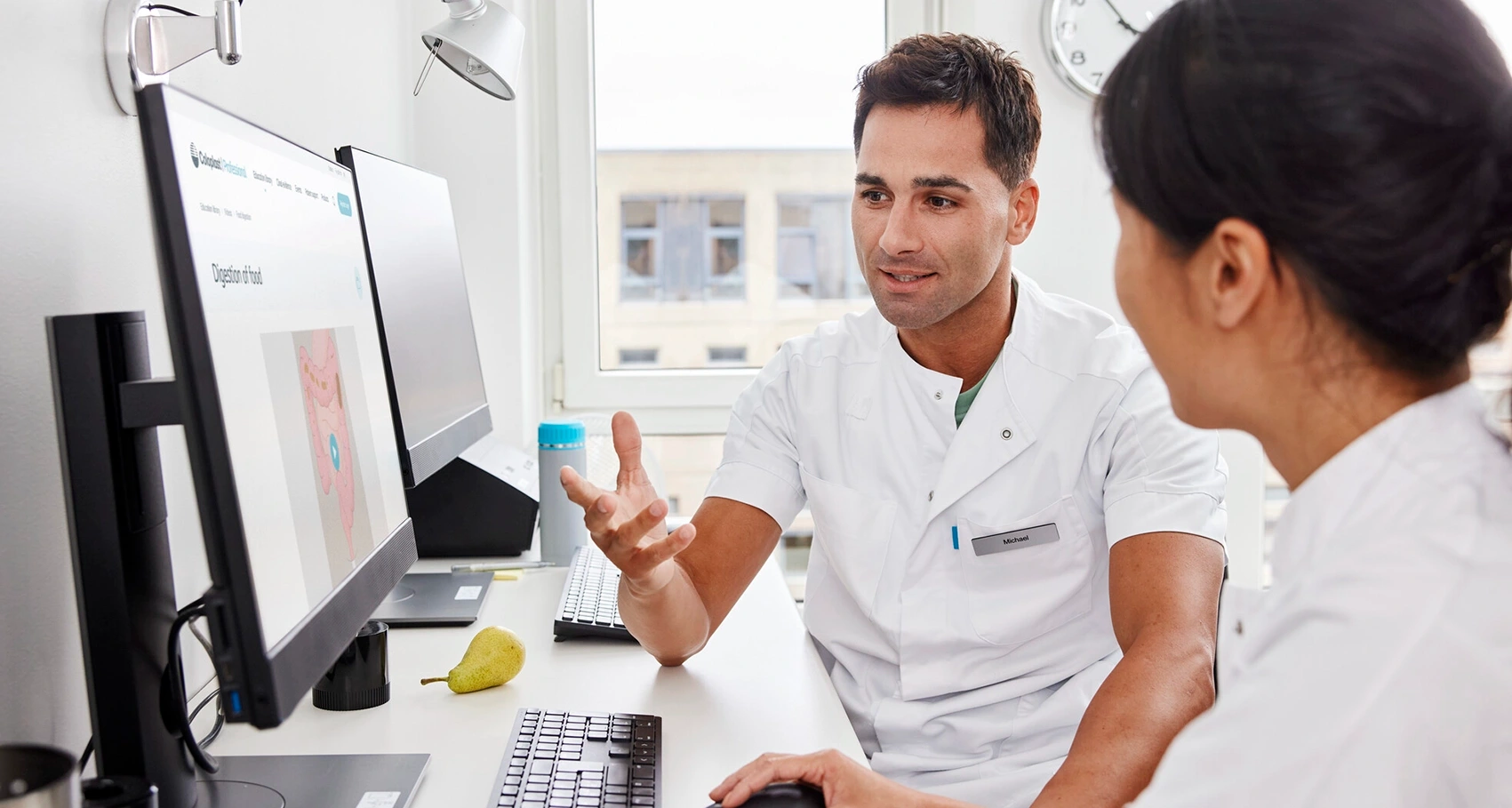 Foto av to helsepersonell som sitter ved en datamaskin. Multippel sklerose kan forårsake tarmdysfunksjon. Det finnes flere behandlingsmetoder som kan brukes til å behandle og håndtere symptomene 