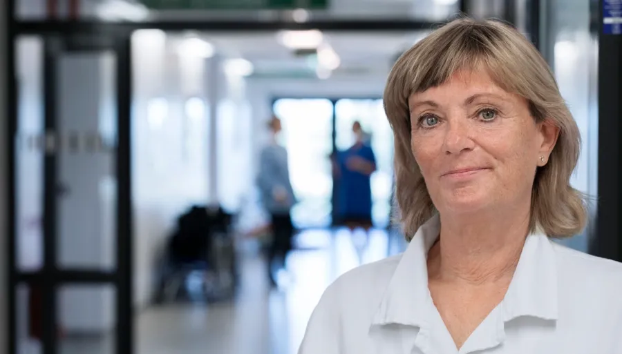 Portrettfoto av Anna, helsepersonell. Transanal irrigasjon (TAI) innebærer å føre vann inn i tarmen for å tømme avføring i endetarmen og nedre del av tykktarmen. 