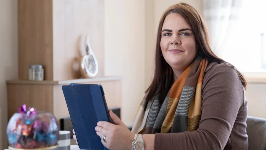 Foto av Sarah sittende ved et bord. Det var fire år etter Sarahs første diagnose at hun koblet blæreproblemene sine til MS. 