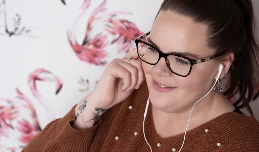 Portrettfoto av Sarah som lytter til musikk. Sarah fikk diagnosen MS og bruker kateter for å håndtere blæreproblemene.  