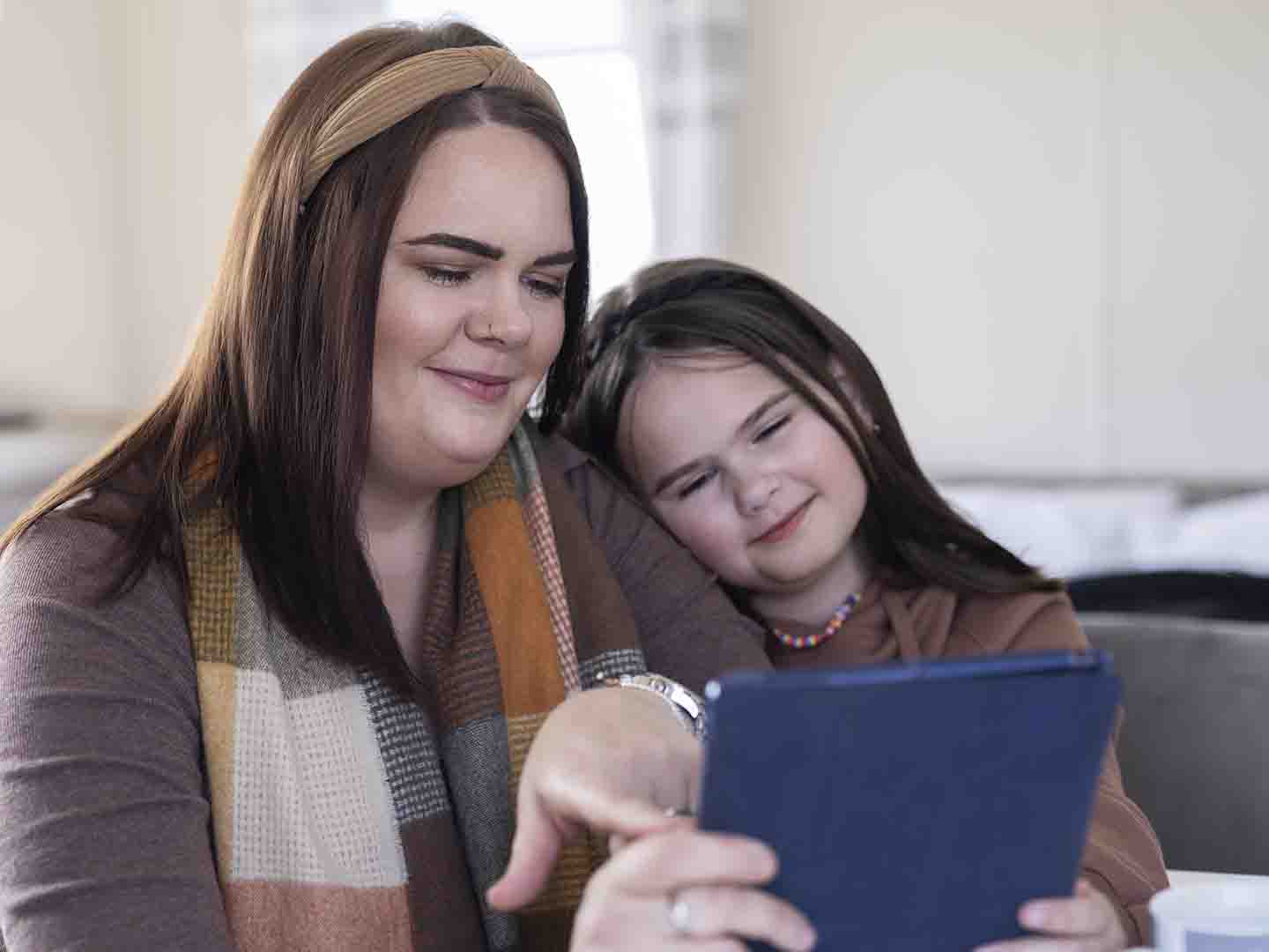 Kvinne og barn ser på en iPad