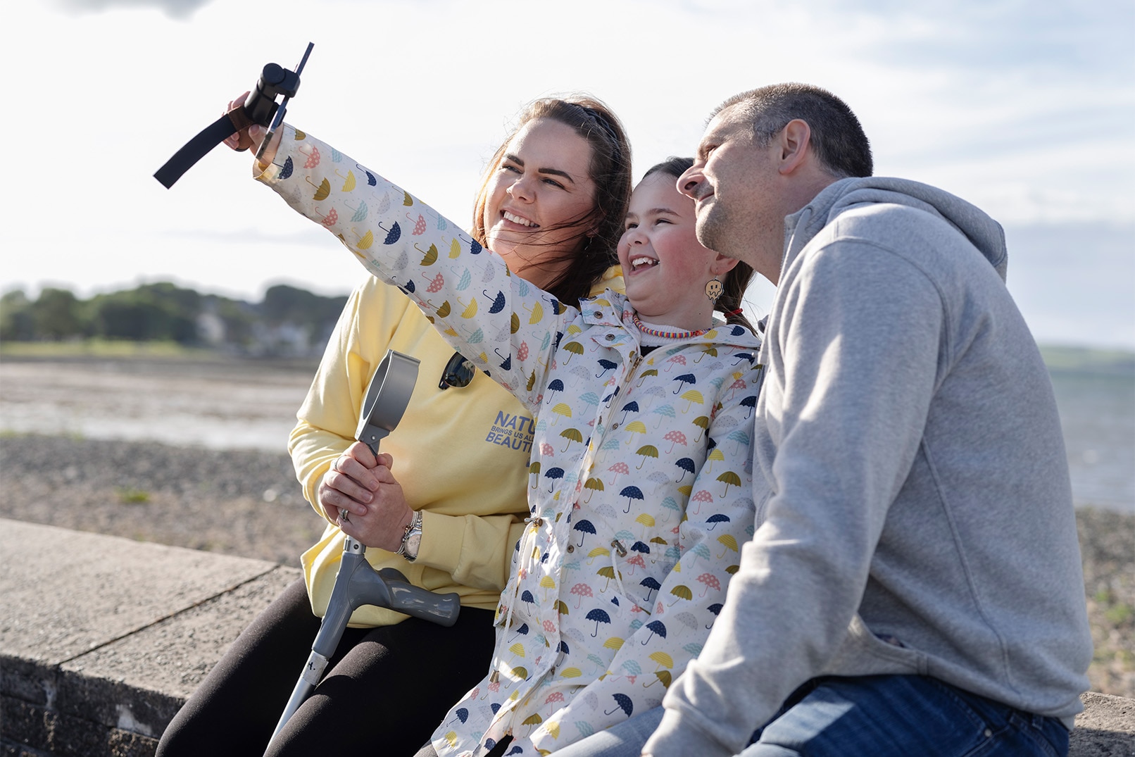 Sarah sammen med mannen og datteren, der datteren tar en selfie av familien